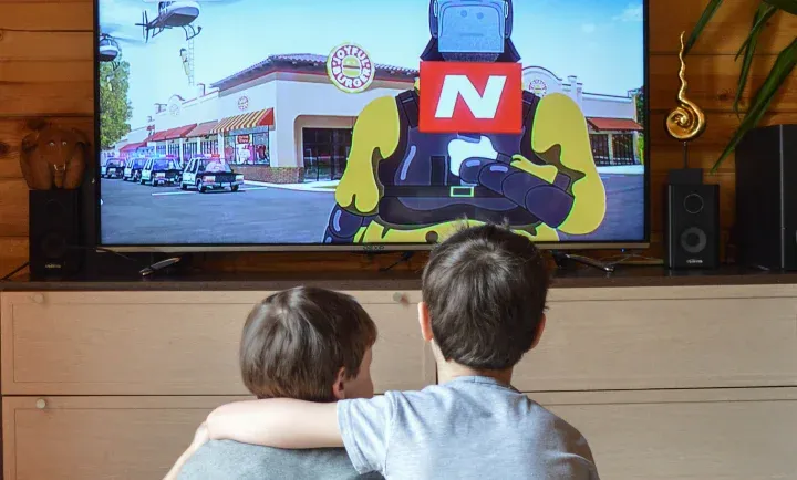 Dos niños viendo televisión juntos en casa